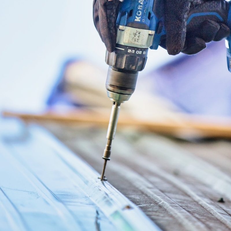 a person using a drill to drill a piece of wood